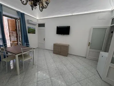 a dining room with a table and a tv on the wall at Fauka blu in Carini