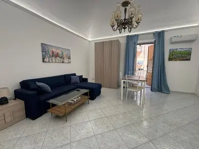 a living room with a blue couch and a table at Fauka blu in Carini