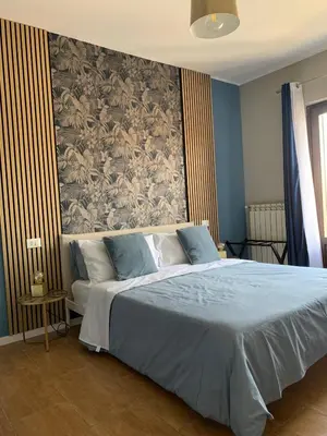 a bedroom with a large bed with a wall at CentruMassimo Apartment in Palermo