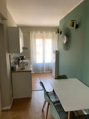 a kitchen with a white table and chairs in a kitchen at CentruMassimo Apartment in Palermo