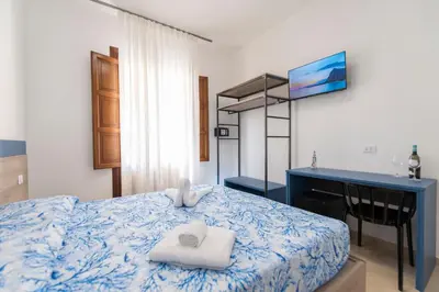 a bedroom with a bed and a desk with towels on it at Un tocco di San Vito in San Vito lo Capo
