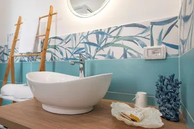 a bathroom with a white bowl sink on a wooden table at Un tocco di San Vito in San Vito lo Capo