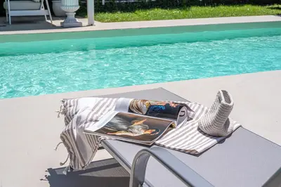 a magazine sitting on a table next to a swimming pool at Villa Nika in Palermo