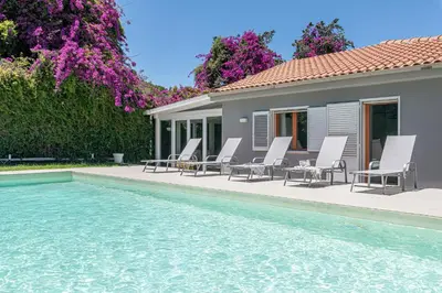 a group of chairs sitting next to a swimming pool at Villa Nika in Palermo