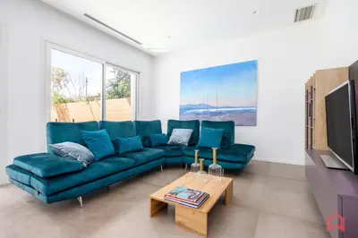 a living room with a blue couch and a table at Appartamento in villa con piscina privata in Palermo