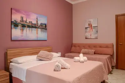 a bedroom with two beds and a painting on the wall at A casa di Pam in Palermo