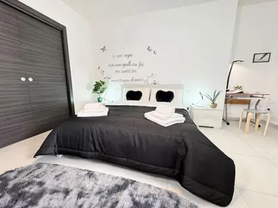 a large black bed in a bedroom with a desk at Attico Magnificent [Wi-Fi/Free Parking] in Palermo