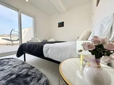a bedroom with a bed and a table with flowers at Attico Magnificent [Wi-Fi/Free Parking] in Palermo