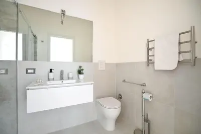 a white bathroom with a toilet and a sink at iFlat Normanni Lounge Apartment in Palermo