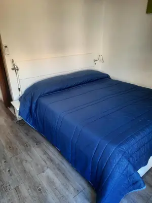 a blue bed in a room with a white wall at EMILY'S HOUSE in Palermo