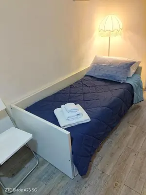 a bed with a purple comforter and a lamp at EMILY'S HOUSE in Palermo