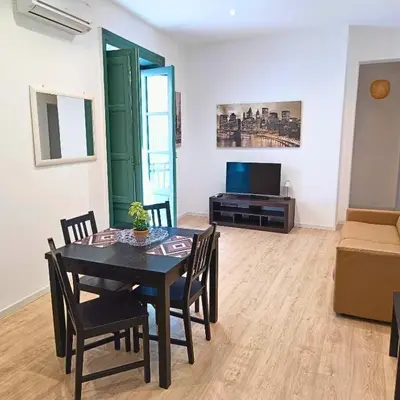 a dining room with a table and chairs and a television at [CENTRO STORICO] Casa Bellini ***** in Palermo