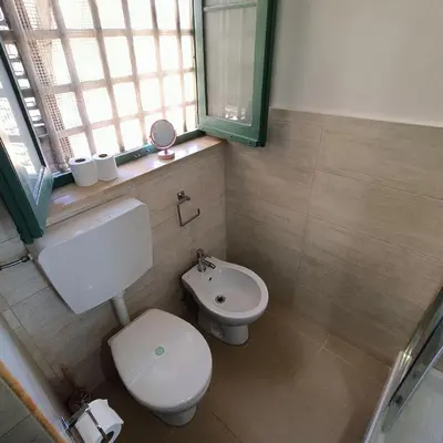 a bathroom with a toilet and a sink and a window at [CENTRO STORICO] Casa Bellini ***** in Palermo