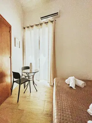 a bedroom with a bed and a table and a chair at Monteleone rooms in Palermo