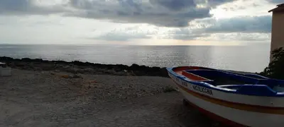 a boat sitting on the ground near the ocean at Casa Vacanze Deianira in Santa Flavia