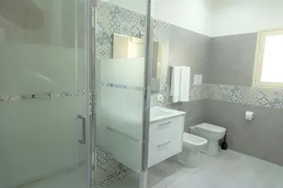 a bathroom with a toilet and a glass shower at Casa Vacanze Altea in Santa Flavia