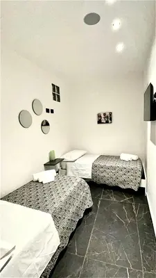 a bedroom with two beds and a table with a desk at Casa Vacanze Donna MariaCarme' in Palermo