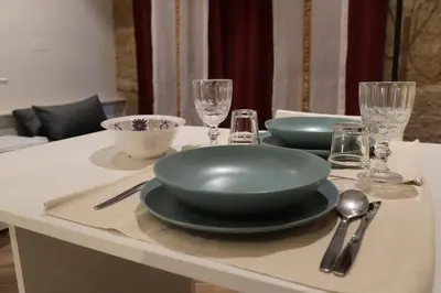 a table with two plates and bowls and glasses on it at Casuzza palazzo storico, Stazione Centrale Palermo in Palermo