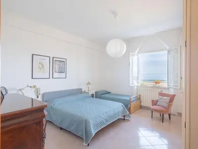 a bedroom with a bed and a chair and a window at Villa Moon Total Relax in Alcamo