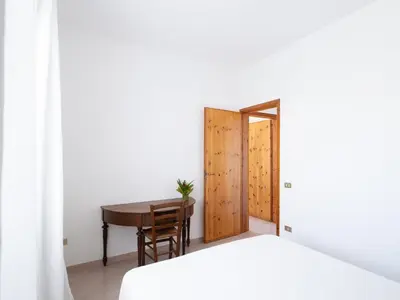 a bedroom with a desk and a table and a door at Villa Moon Total Relax in Alcamo