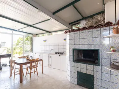 a kitchen with a fireplace and a table and chairs at Villa Moon Total Relax in Alcamo