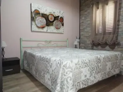 a bedroom with a bed and a painting on the wall at Vista sul mare e splendido terrazzo in Castellammare del Golfo