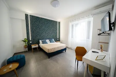 a bedroom with a bed and a desk and a tv at Luna Marie in Palermo
