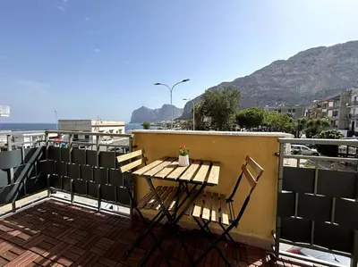 a table and chairs on a balcony with a view of the ocean at Casa sul Mare alle porte di Palermo in Isola delle Femmine