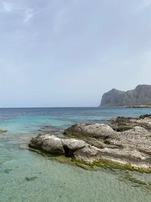 a beach with some rocks in the water at Casa sul Mare alle porte di Palermo in Isola delle Femmine