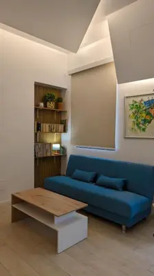 a living room with a blue couch and a table at Don Armando al Massimo in Palermo