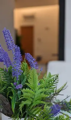 a vase filled with purple flowers and green plants at Don Armando al Massimo in Palermo