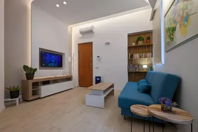 a living room with a blue couch and a tv at Don Armando al Massimo in Palermo