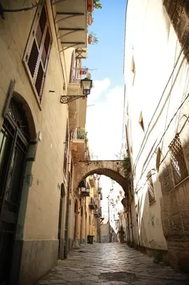 an alley with an arch between two buildings at La Maison Du Centre in Palermo