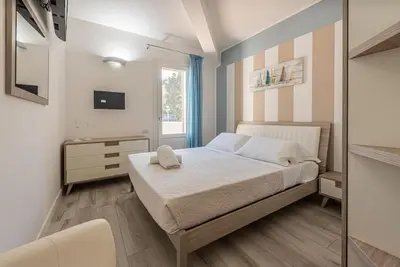 a bedroom with a large white bed and a window at Villa Solià - Villa indipendente con Piscina e Giardino in Campofelice di Roccella