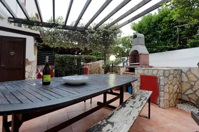 a balcony of a house with a table and plants at Rosa Di Makari in Macari