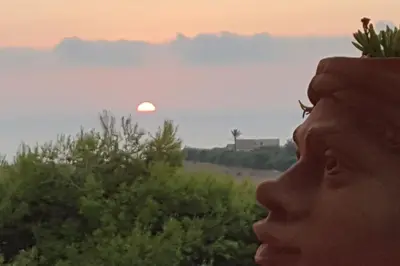 a man looking up at the sunset at VILLA FLAMINIA - con piscina privata in San Vito lo Capo