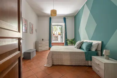 a bedroom with a bed with blue walls and a window at Good Vibes apartment nel centro storico in Palermo