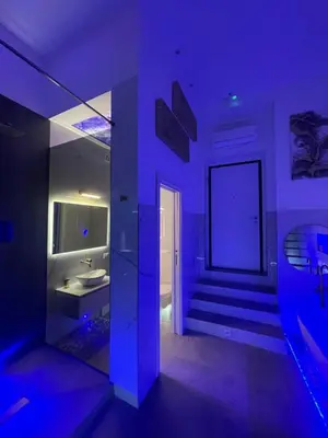 a purple room with a bathroom with a sink at ARCUM suites in Palermo