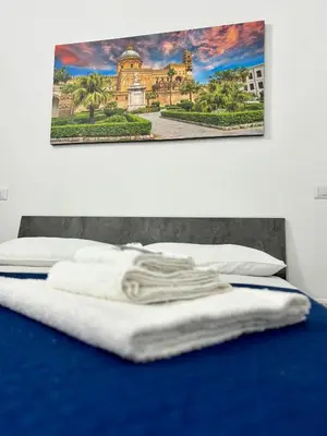 a towel on a bed with a picture on the wall at Casa vacanze La Bonta' di Palermo in Palermo