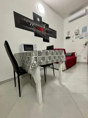 a dining room with a table and a couch at Casa vacanze La Bonta' di Palermo in Palermo