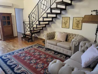 a living room with a couch and a staircase at Patrizia Chic in Palermo