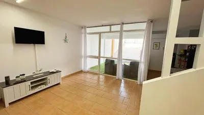 a living room with a flat screen tv and a large window at Casa del Limone in Isola delle Femmine