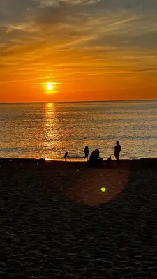 a group of people on the beach at sunset at Casa del Limone in Isola delle Femmine