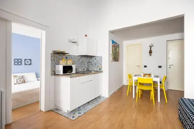 a kitchen and dining room with a table and yellow chairs at Agata & Rosalia 2 Suite Indipendenti e Comunicanti con Balcone & AC in Palermo