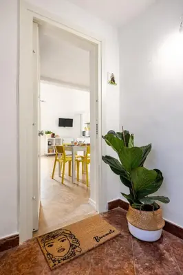 a living room with a potted plant and a table at Agata & Rosalia 2 Suite Indipendenti e Comunicanti con Balcone & AC in Palermo