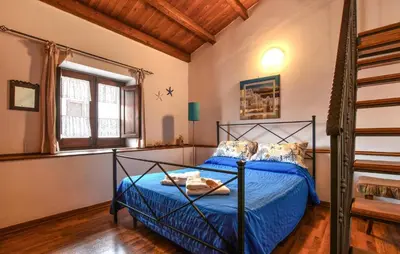 a bedroom with a bed with blue sheets and a window at Stunning Home In Trappeto With Wifi in Trappeto