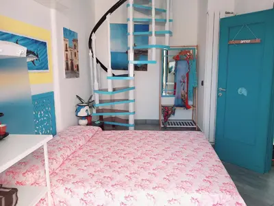 a bedroom with a bed and a spiral staircase at Villa Mondello Jacuzzi Room e Terraces Room in Mondello