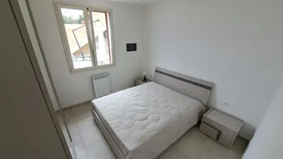 a small bedroom with a bed and a window at Villini AltaVista in Altavilla Milicia