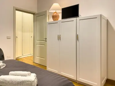 a bedroom with white cabinets with a flat screen tv on top at Flat44 in Palermo