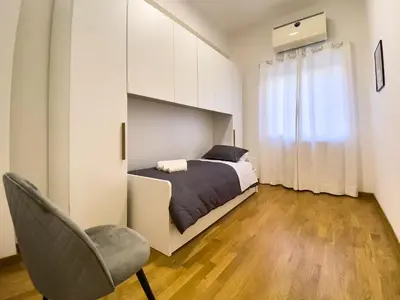 a bedroom with a bed and a chair at Flat44 in Palermo